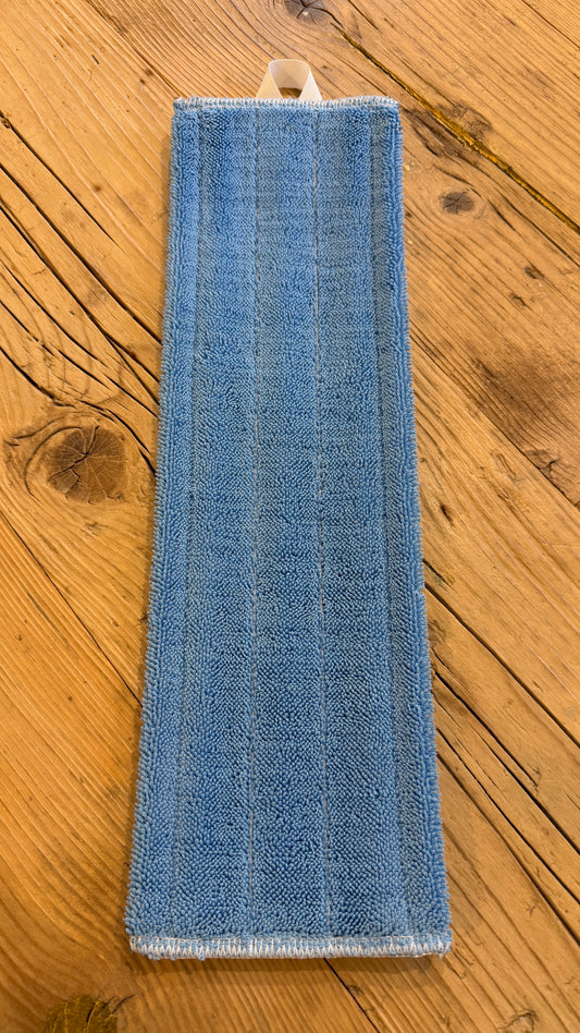 Panno in microfibra azzurra PARÁL cm 40x11 appoggiato su un pavimento in legno